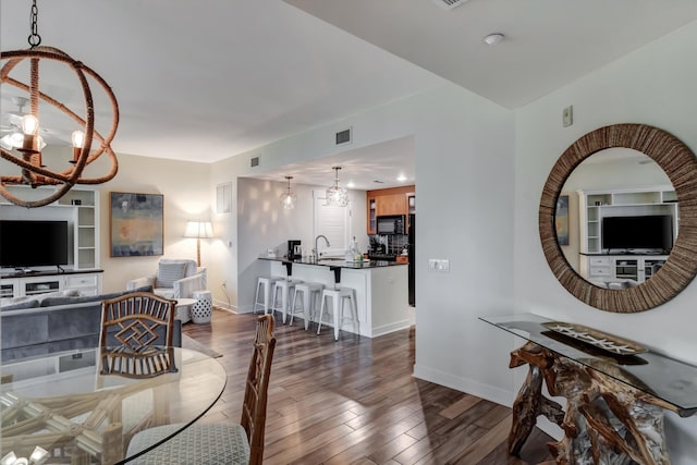 living room with dark hardwood / wood-style floors, a chandelier, and sink