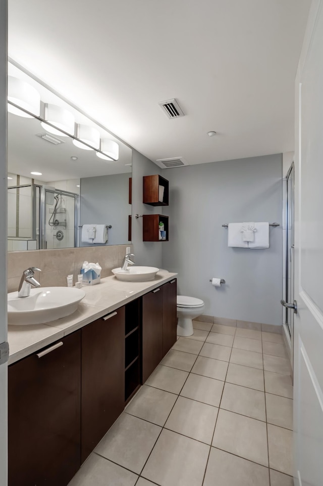 bathroom with tile patterned floors, toilet, an enclosed shower, and vanity