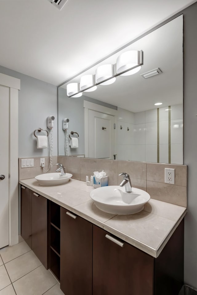 bathroom featuring tile patterned flooring, backsplash, and vanity