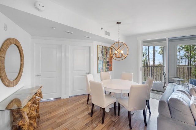 dining room with a chandelier and light hardwood / wood-style floors