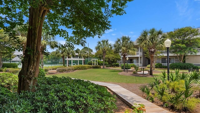 surrounding community featuring a pergola and a lawn