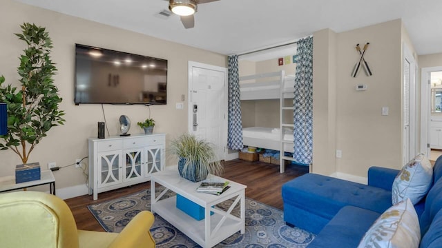 living room featuring dark wood-type flooring and ceiling fan