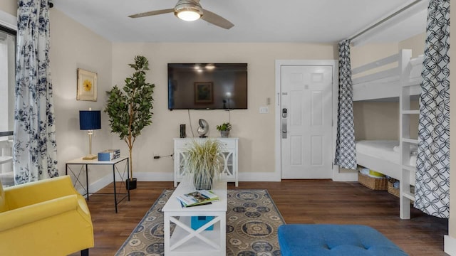 living room with ceiling fan and dark hardwood / wood-style flooring