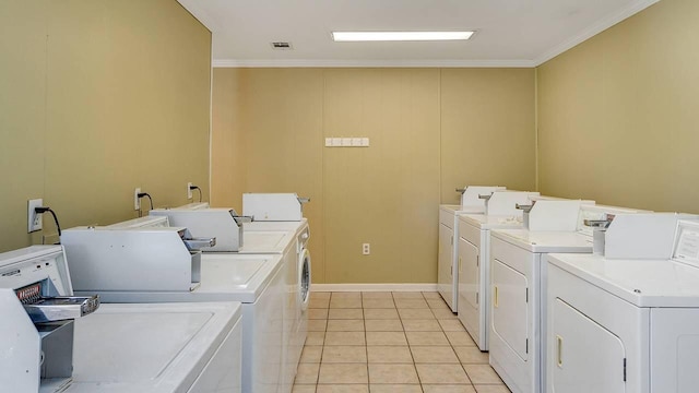 laundry area with light tile patterned flooring, crown molding, and washer and dryer