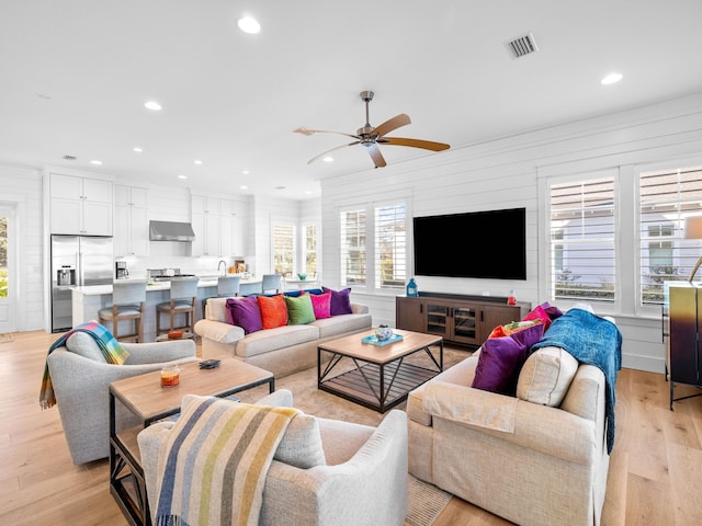 living room featuring light hardwood / wood-style flooring and ceiling fan