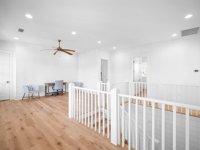 hallway featuring ornamental molding and light wood-type flooring