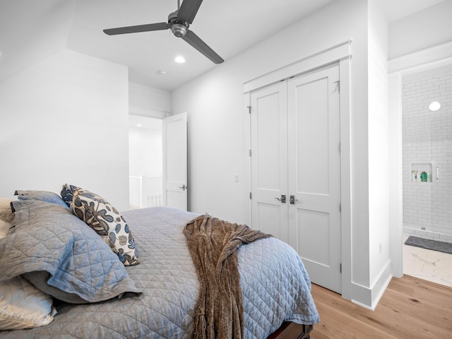 bedroom with a closet, ceiling fan, light wood-type flooring, and ensuite bath