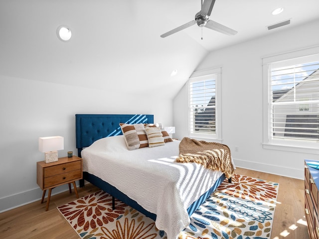 bedroom with ceiling fan, lofted ceiling, wood-type flooring, and multiple windows