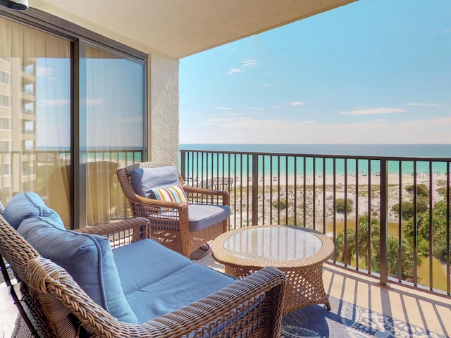 balcony featuring a beach view and a water view