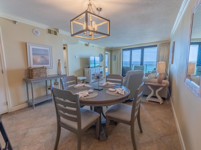 dining area with an inviting chandelier, ornamental molding, and a textured ceiling