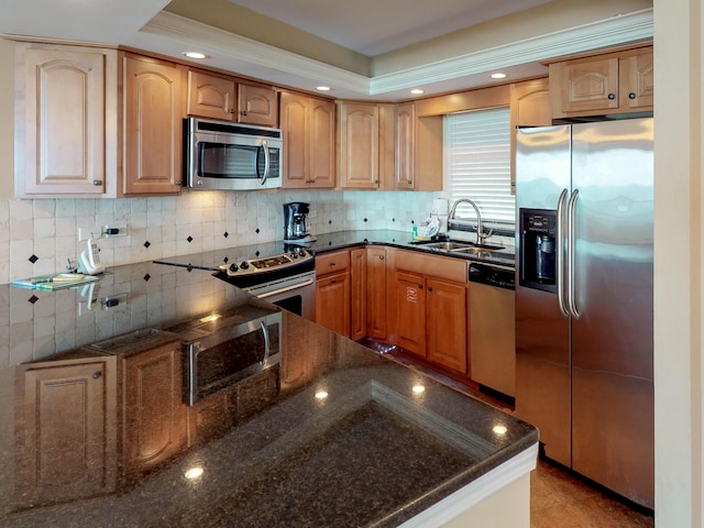 kitchen with sink, decorative backsplash, dark stone counters, and appliances with stainless steel finishes