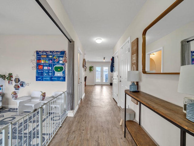 hall with french doors and light hardwood / wood-style floors