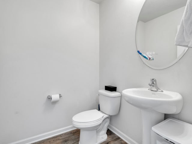 bathroom featuring wood-type flooring and toilet