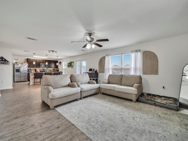 living room featuring ceiling fan and light wood-type flooring