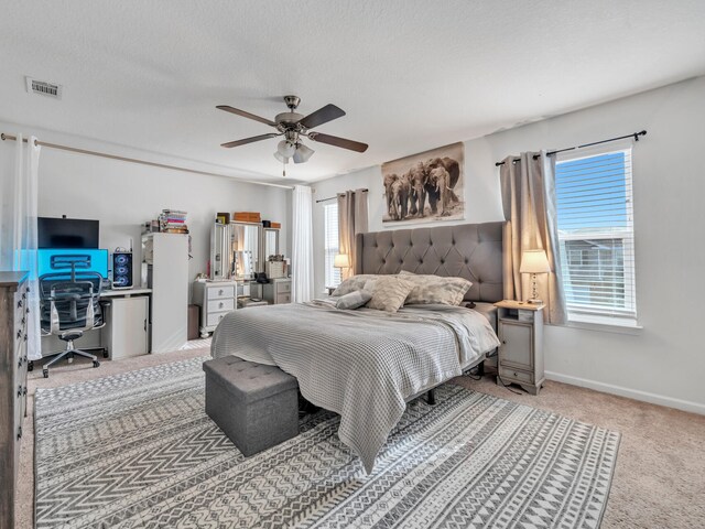 carpeted bedroom with ceiling fan and a textured ceiling