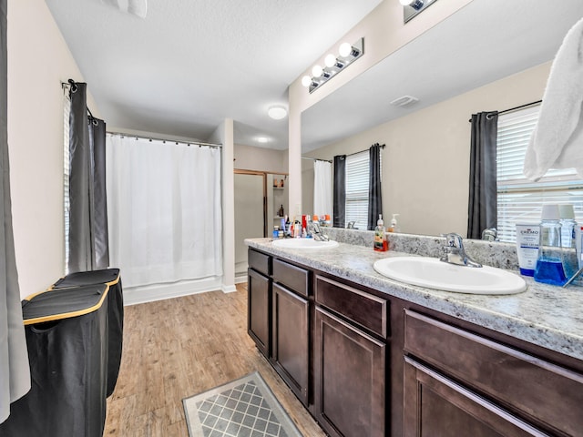 bathroom featuring hardwood / wood-style flooring, vanity, and a shower