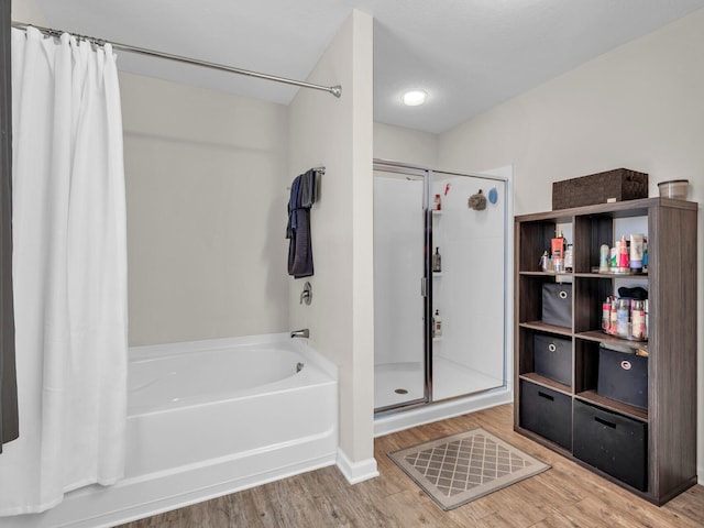 bathroom with hardwood / wood-style flooring and shower with separate bathtub