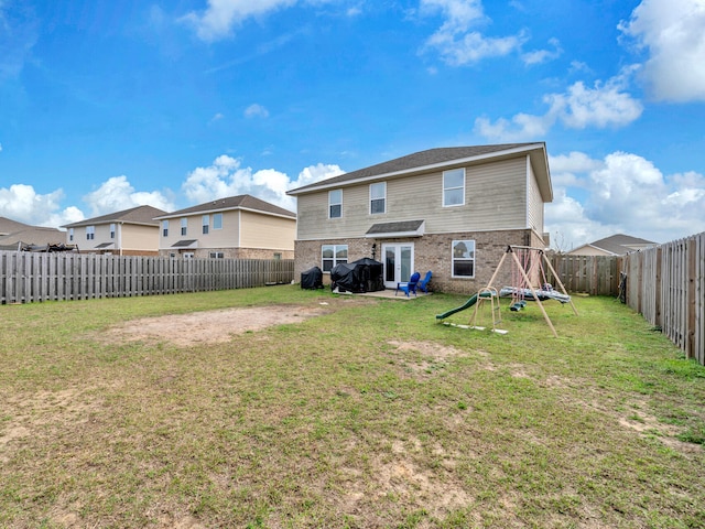 rear view of property with a patio, a playground, and a lawn