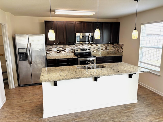 728 Widgeon Way, Crestview, FL 32539 - kitchen featuring appliances with stainless steel finishes, a sink, decorative backsplash, and a kitchen bar
