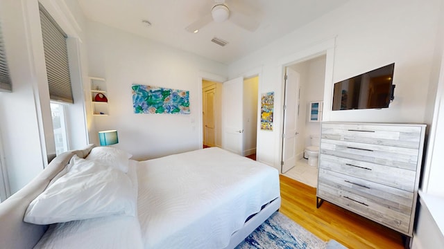 bedroom with ceiling fan, connected bathroom, and light hardwood / wood-style floors