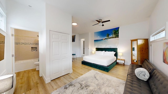 bedroom with connected bathroom and hardwood / wood-style flooring