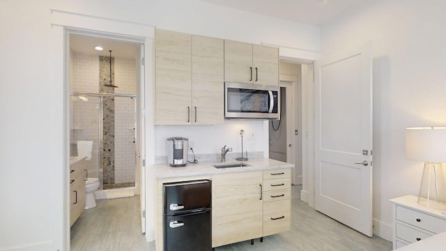 kitchen featuring sink, decorative light fixtures, and light wood-type flooring