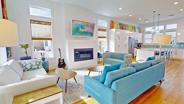 living room featuring a towering ceiling and light hardwood / wood-style floors