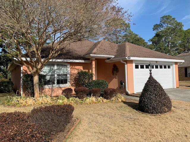 single story home with a garage and a front lawn