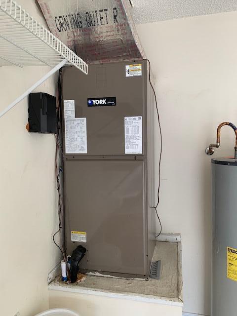 utility room featuring heating unit and gas water heater