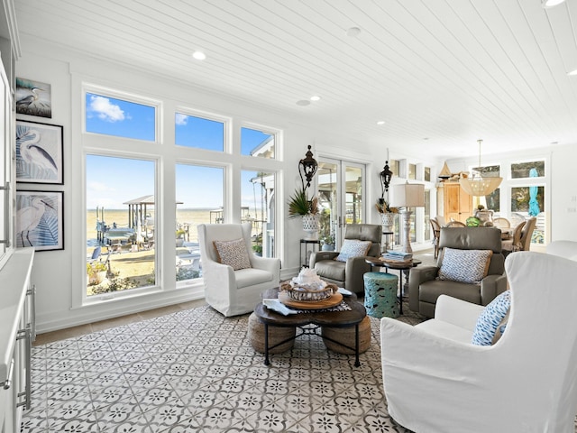 living area featuring french doors, a notable chandelier, recessed lighting, a water view, and wood ceiling