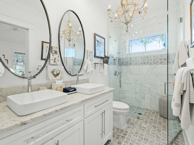 full bath with a sink, a marble finish shower, and an inviting chandelier