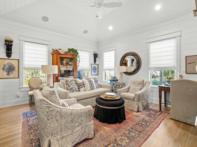 living area with light wood-style floors, baseboards, and a wealth of natural light