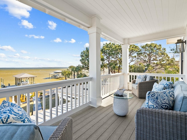 wooden terrace with a water view and an outdoor living space