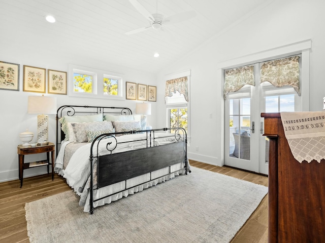 bedroom with baseboards, wood finished floors, access to outside, vaulted ceiling, and recessed lighting