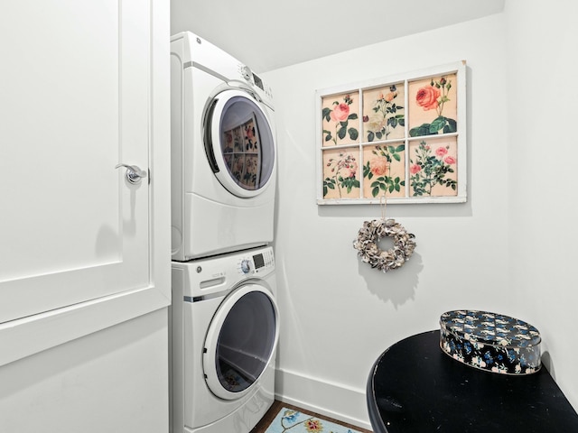 laundry area featuring laundry area, stacked washer / dryer, and baseboards