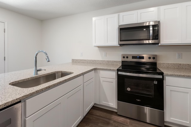 781 Girl Scout Rd, Defuniak Springs, FL 32433 - kitchen featuring appliances with stainless steel finishes, a sink, white cabinetry, dark wood finished floors, and light stone counters