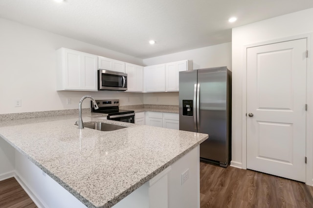 781 Girl Scout Rd, Defuniak Springs, FL 32433 - kitchen featuring stainless steel appliances, a peninsula, dark wood-style floors, white cabinets, and a sink