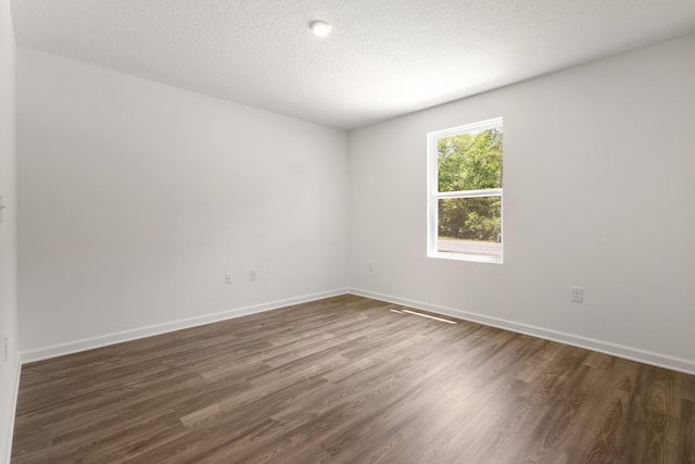 781 Girl Scout Rd, Defuniak Springs, FL 32433 - spare room with dark wood-style flooring, baseboards, and a textured ceiling