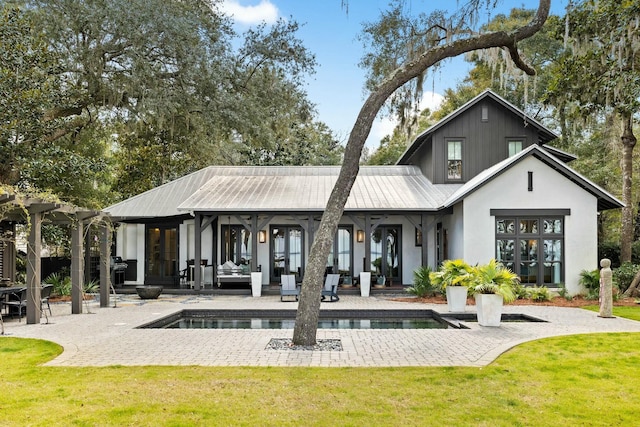 rear view of house featuring a lawn and a patio area