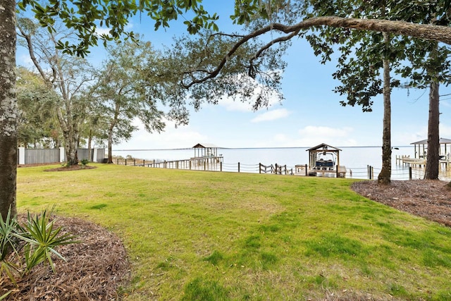 view of yard featuring a water view and a boat dock