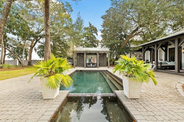 view of swimming pool featuring an outdoor structure, ceiling fan, and a patio area