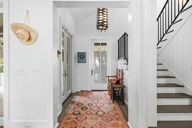 entryway featuring dark wood-type flooring, lofted ceiling, and french doors