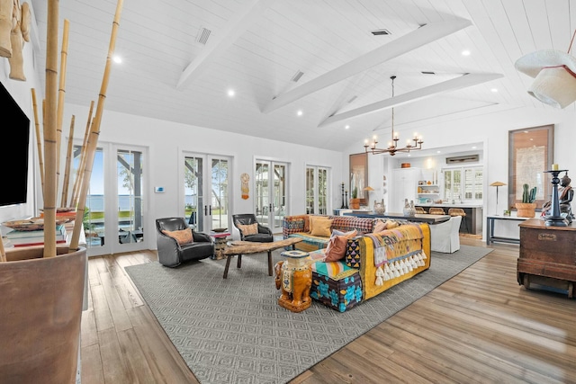 living room featuring light hardwood / wood-style flooring, high vaulted ceiling, beamed ceiling, french doors, and a chandelier