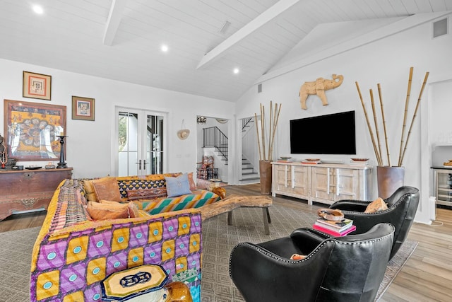 living room with lofted ceiling with beams, light hardwood / wood-style flooring, wood ceiling, and french doors