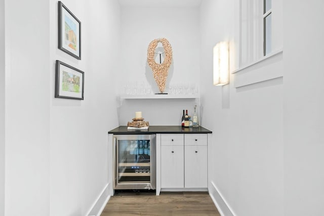 bar featuring white cabinetry, wine cooler, and dark hardwood / wood-style flooring