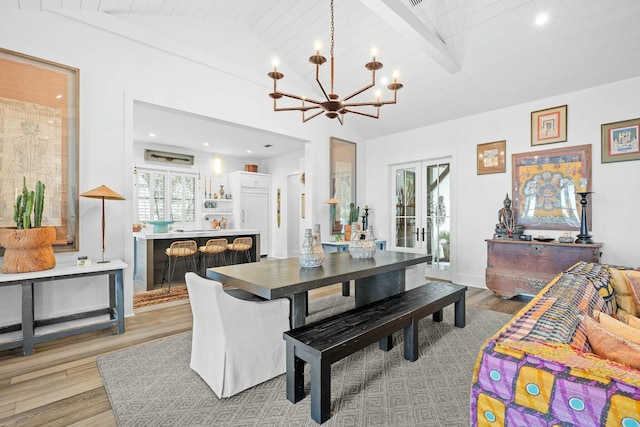 dining space featuring light hardwood / wood-style flooring, vaulted ceiling with beams, a notable chandelier, wooden ceiling, and french doors