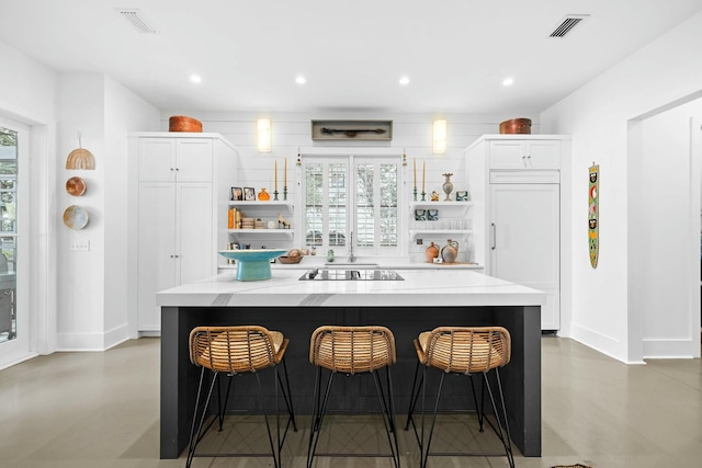 bar featuring white cabinetry, light stone countertops, black electric cooktop, and paneled built in refrigerator