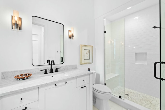 bathroom with vanity, toilet, and a shower with shower door