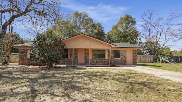 ranch-style house featuring covered porch, fence, a front lawn, and brick siding