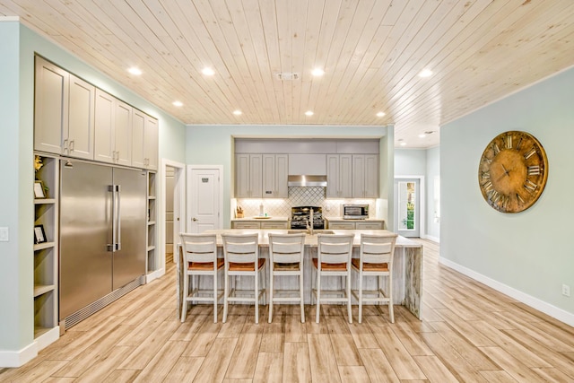 kitchen with a center island with sink, appliances with stainless steel finishes, and a breakfast bar